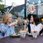 two women eating outside yankee doodle tap room