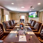 hotel meeting room with long table and brown leather chairs along each side