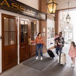 a man, women and child opening a door to Nassau inn