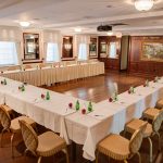 a conference room with a u-shaped table with chairs along the side.