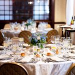 hotel ballroom with tables and chairs. The room and tables are dressed to host a wedding reception.