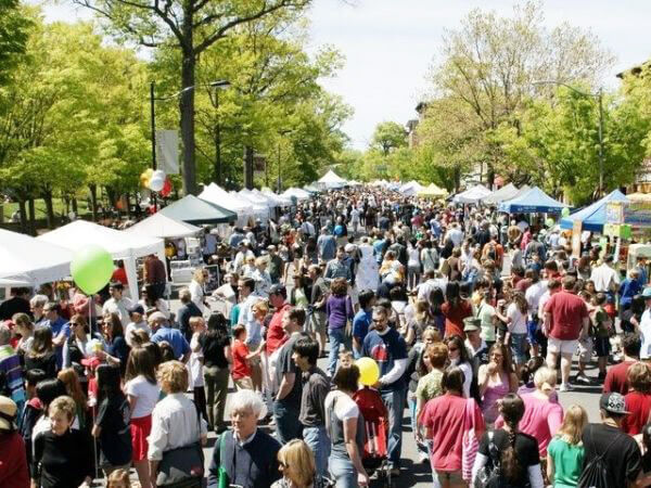 big crowd walking through the streets of Princeton surrounded by tents and vendors on both sides