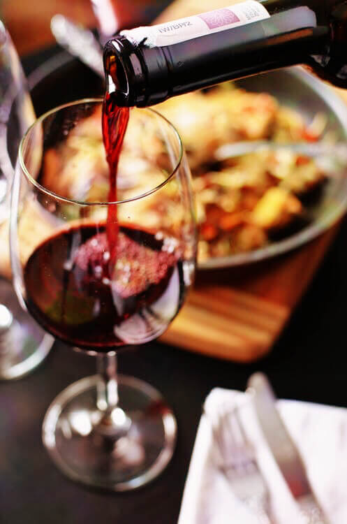 red wine being poured into a wine glass