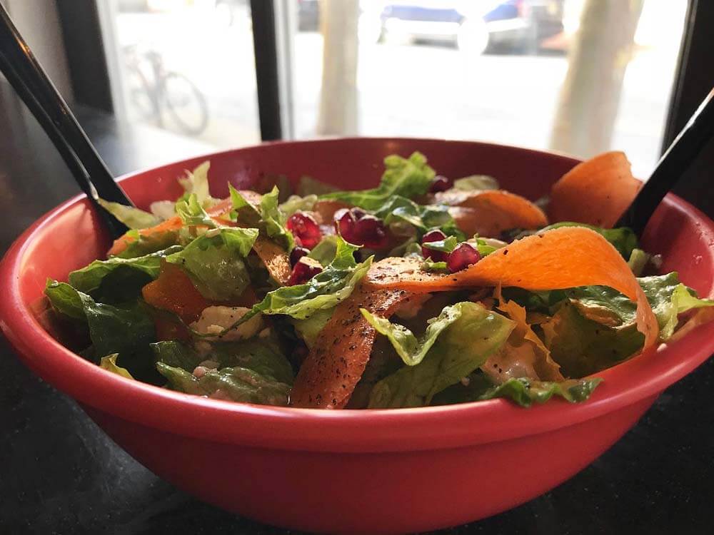 salad from Princeton Soup and Sandwich topped with crispy, sweet pomegranate seeds and carrot shavings