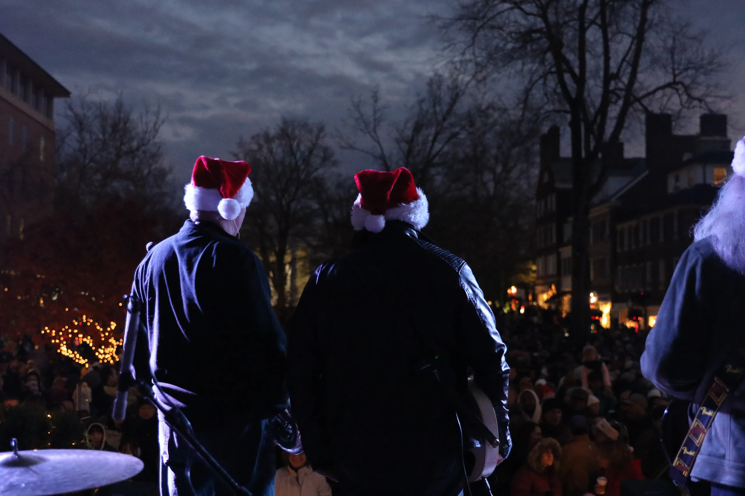 street band performing the image is from behind, they are wearing Santa hats