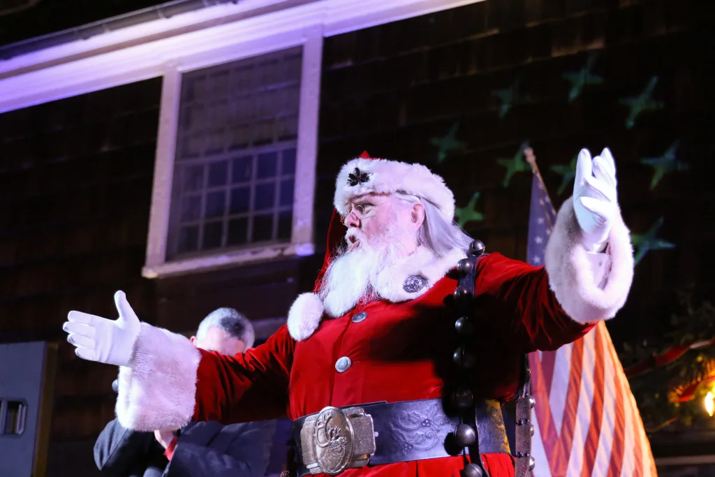 a man dress as Santa Clause with arms open to his side