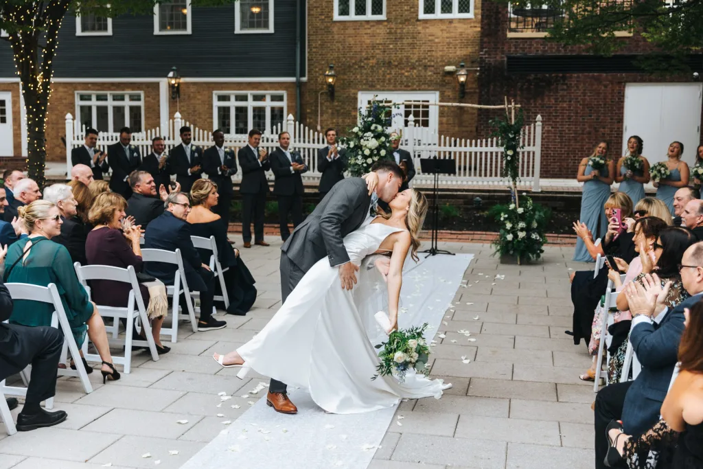 A groom dips his bride at their outdoor wedding ceremony in NJ