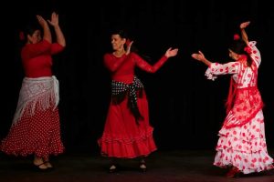 three women dancing in flamenco dresses