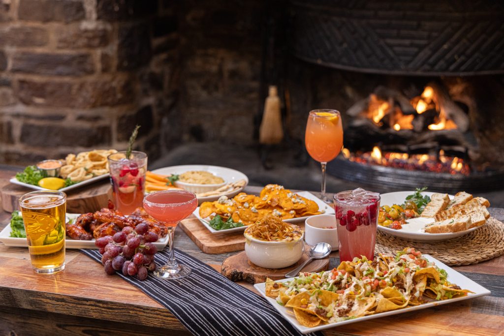 food and drink on table by lit fireplace