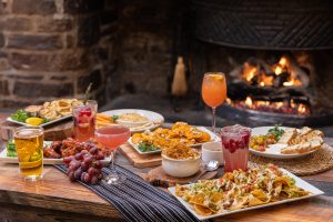 food and drink on table by lit fireplace