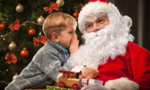 child whispering in santas ear