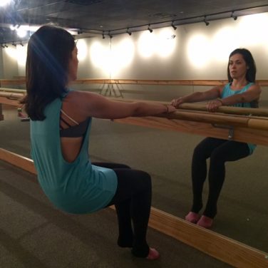 woman at ballet bar in Pure Barre studio