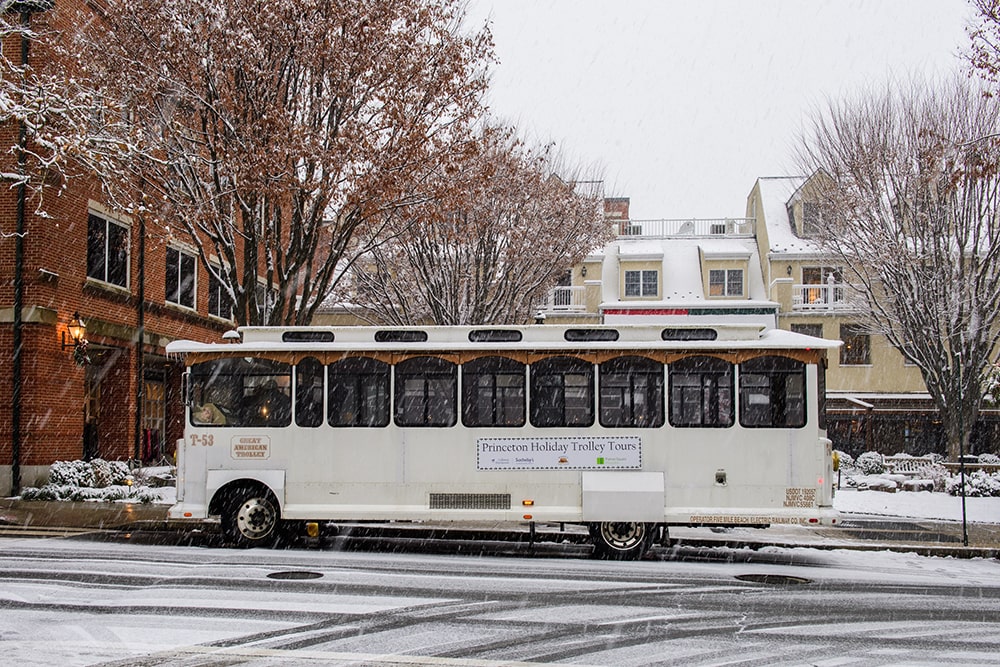 trolley parked on the street while snow dusts the ground
